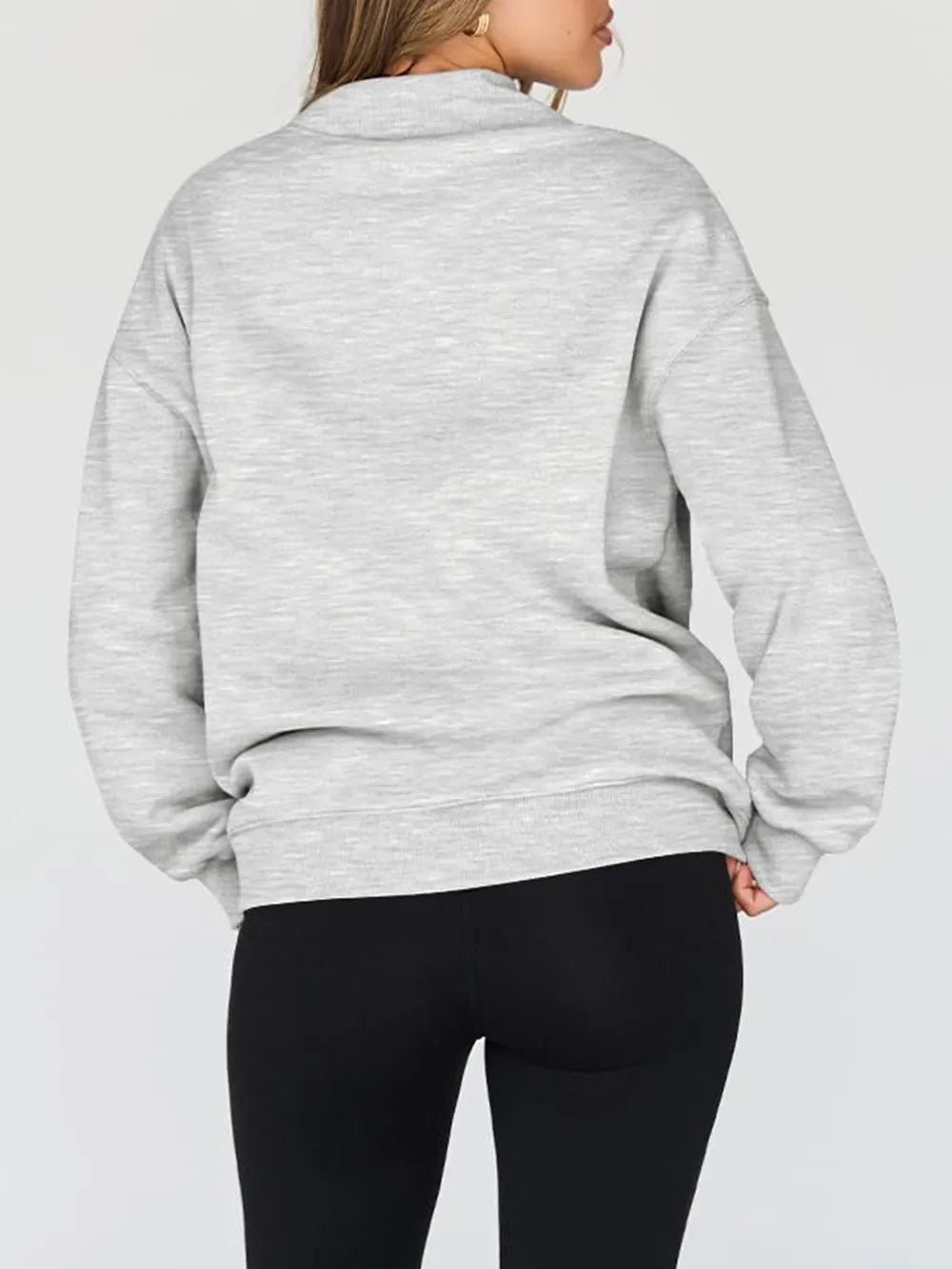 Person wearing a gray sweatshirt against a plain background