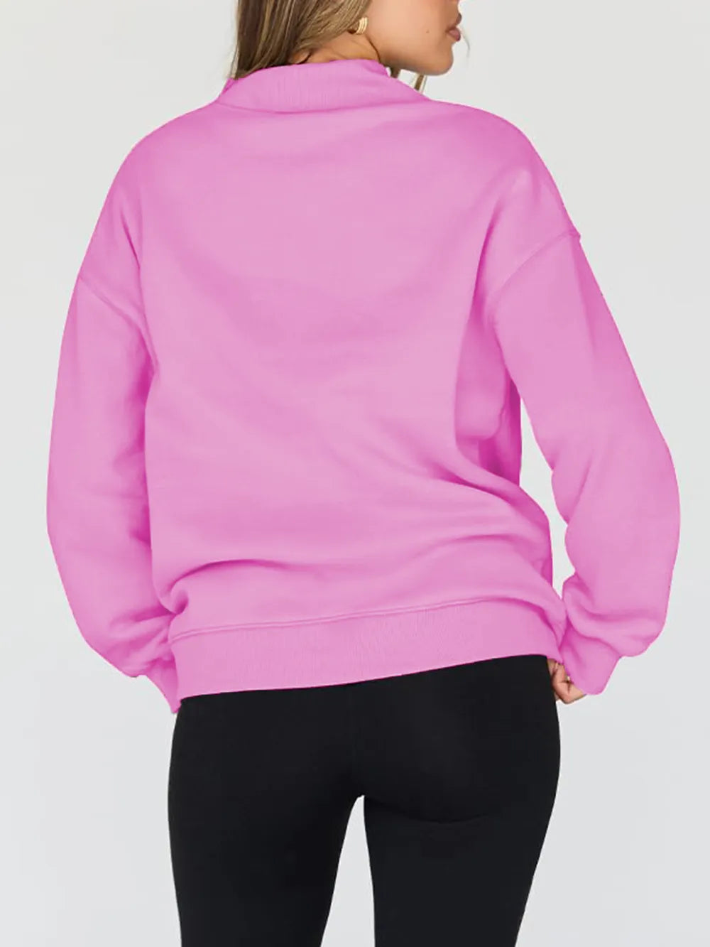 Person wearing a pink sweatshirt on a plain background