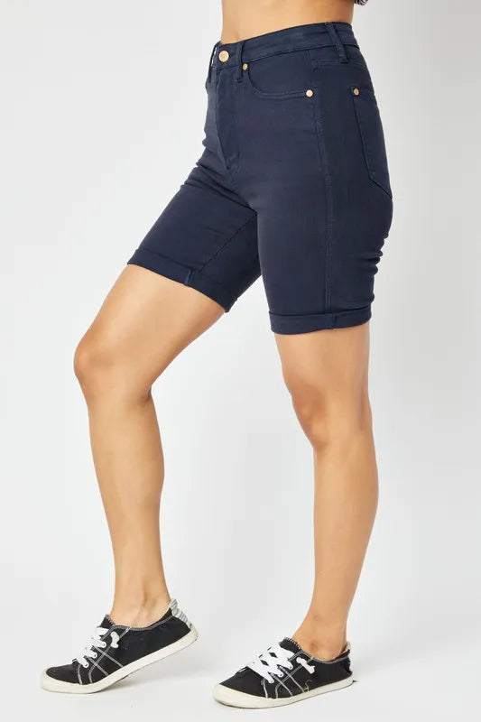 Person wearing navy blue shorts on a white background