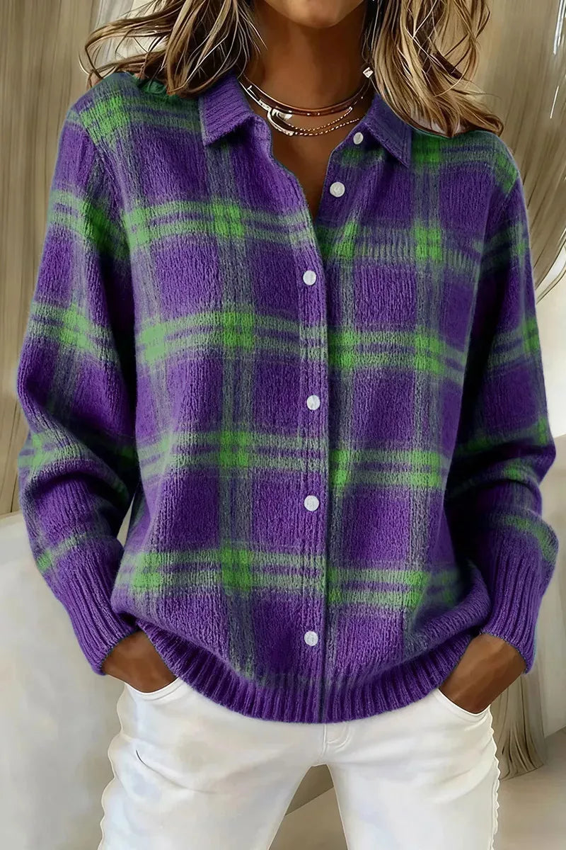 Person wearing a purple and green plaid sweater with white pants.