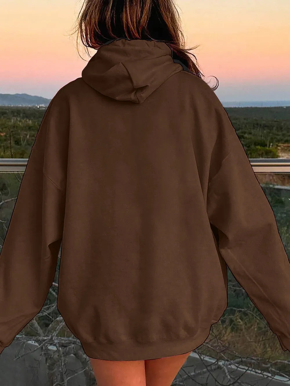 Person wearing a brown jacket with a scenic view in the background