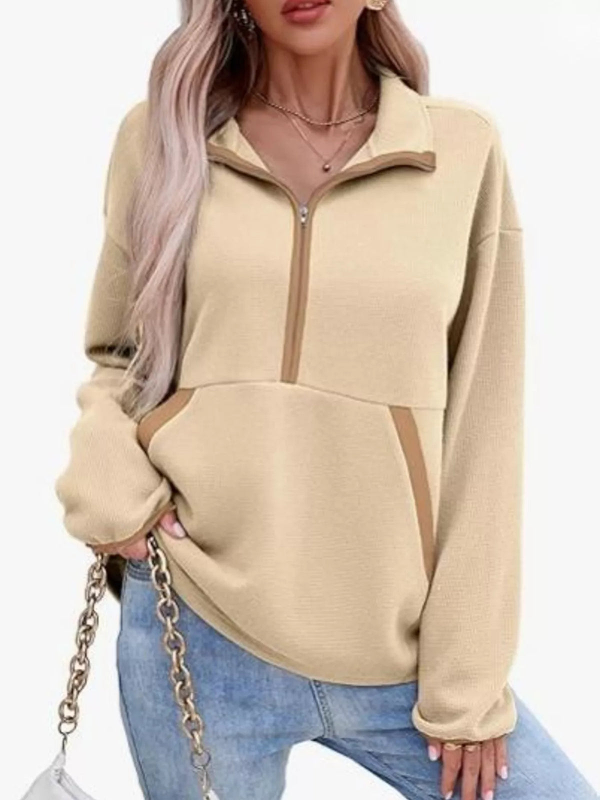 Beige pullover with cut-out design worn by a person on a white background