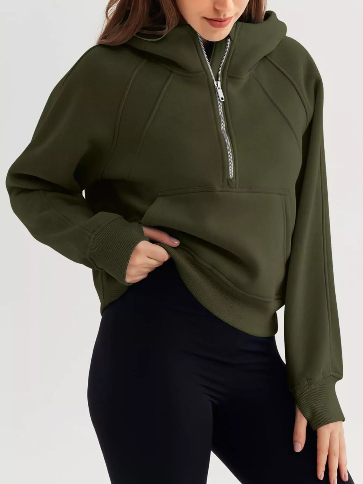 Person wearing a green hoodie with a zipper on a white background