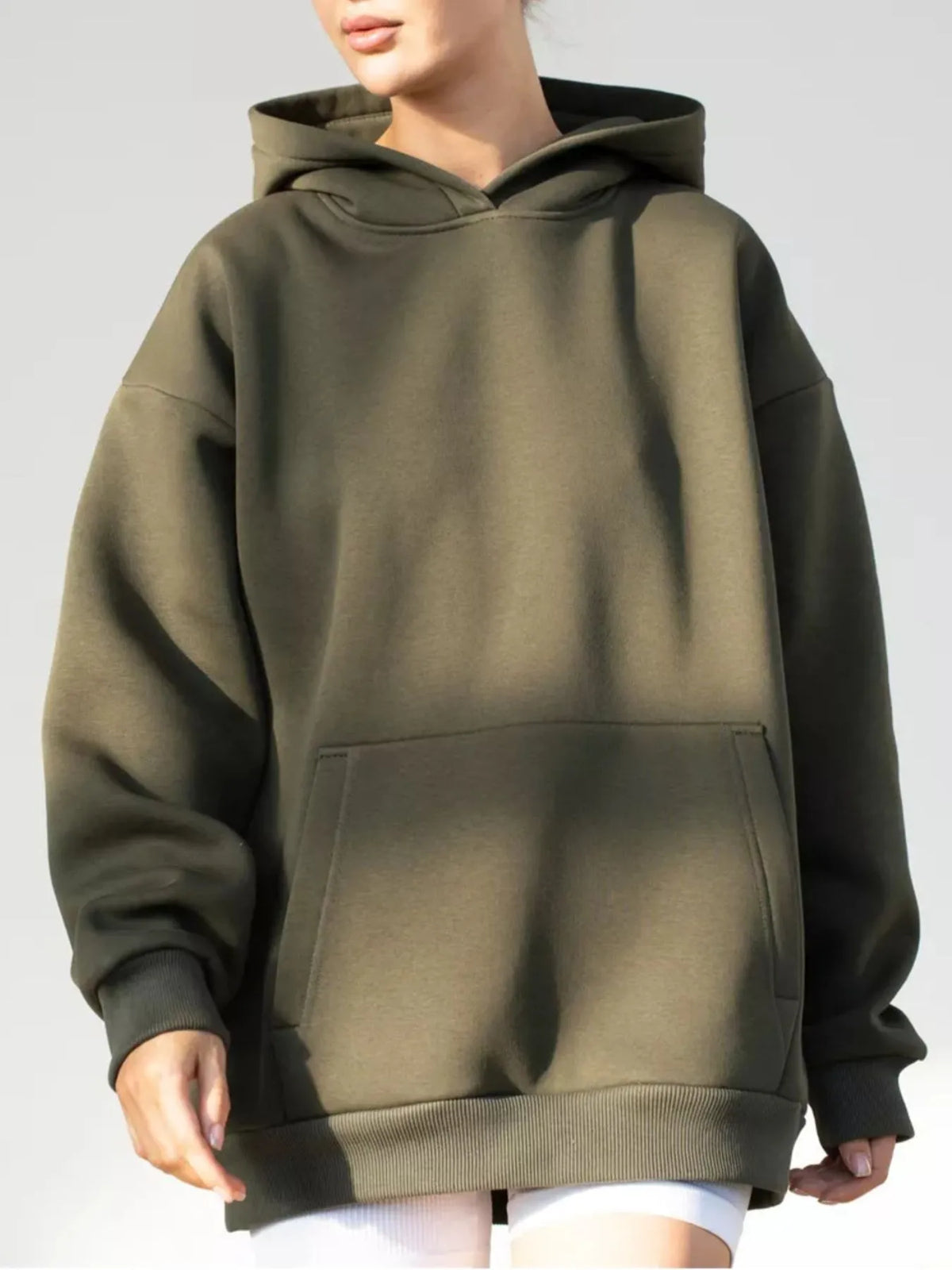 Person wearing a green hoodie on a plain background