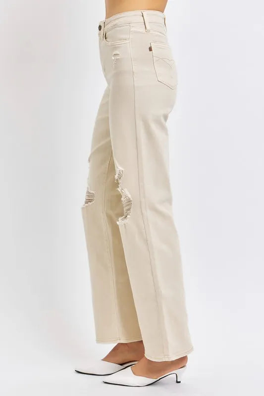 Beige wide-leg jeans worn by a person on a white background