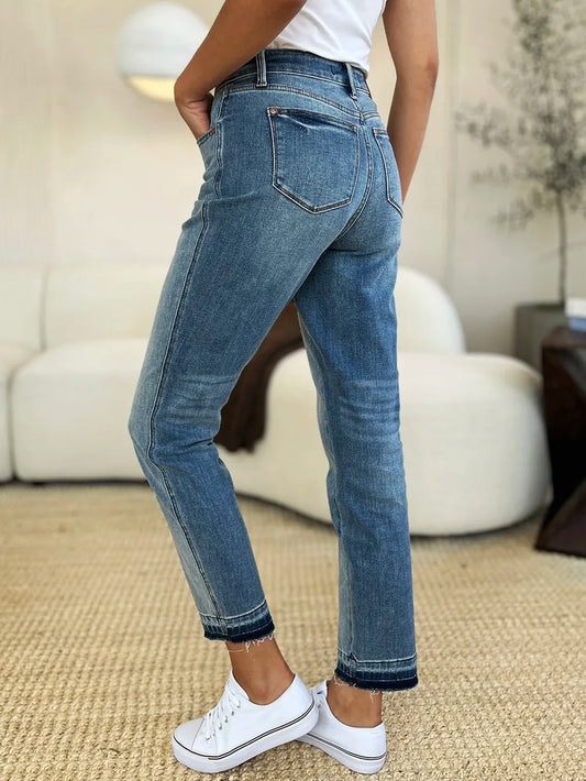 Person wearing blue jeans and white sneakers in a casual setting