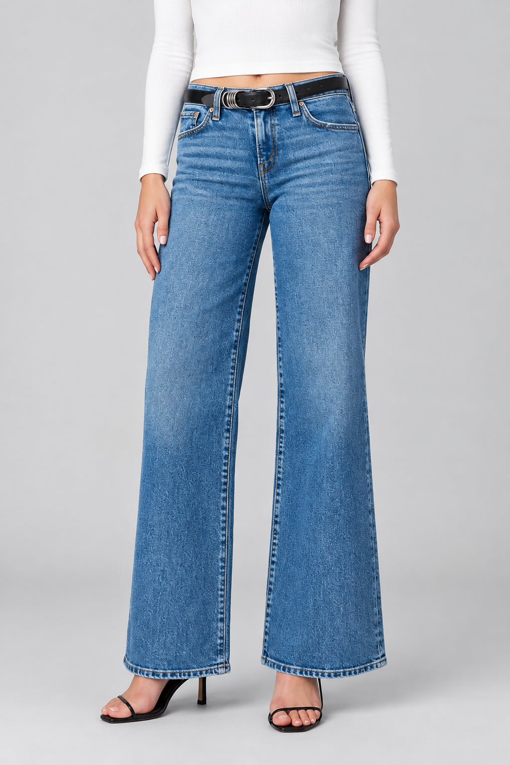 Blue jeans worn by a person on a neutral background