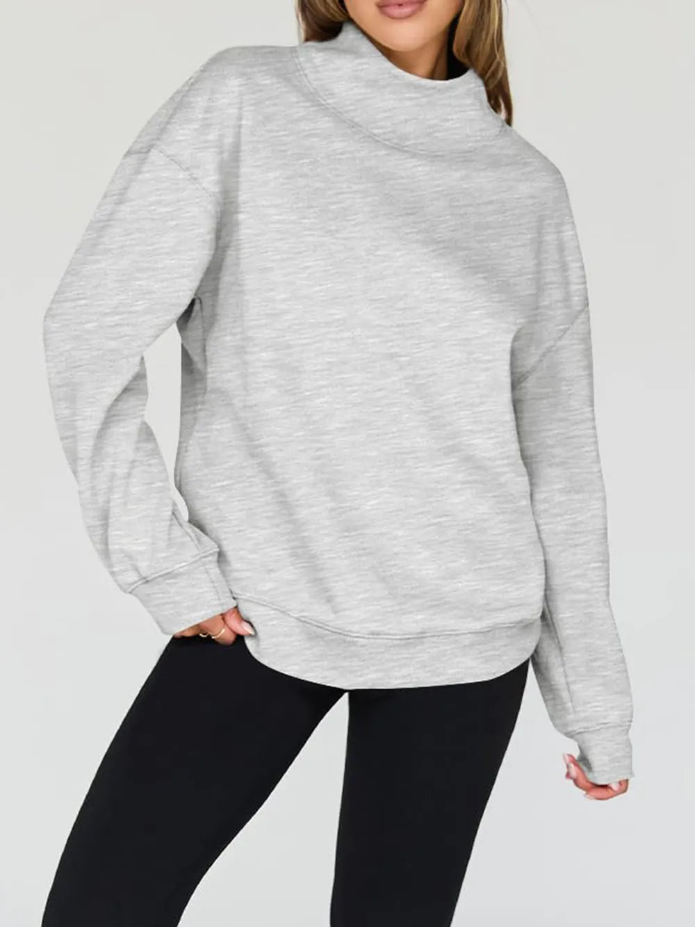 Person wearing a gray sweatshirt against a plain background