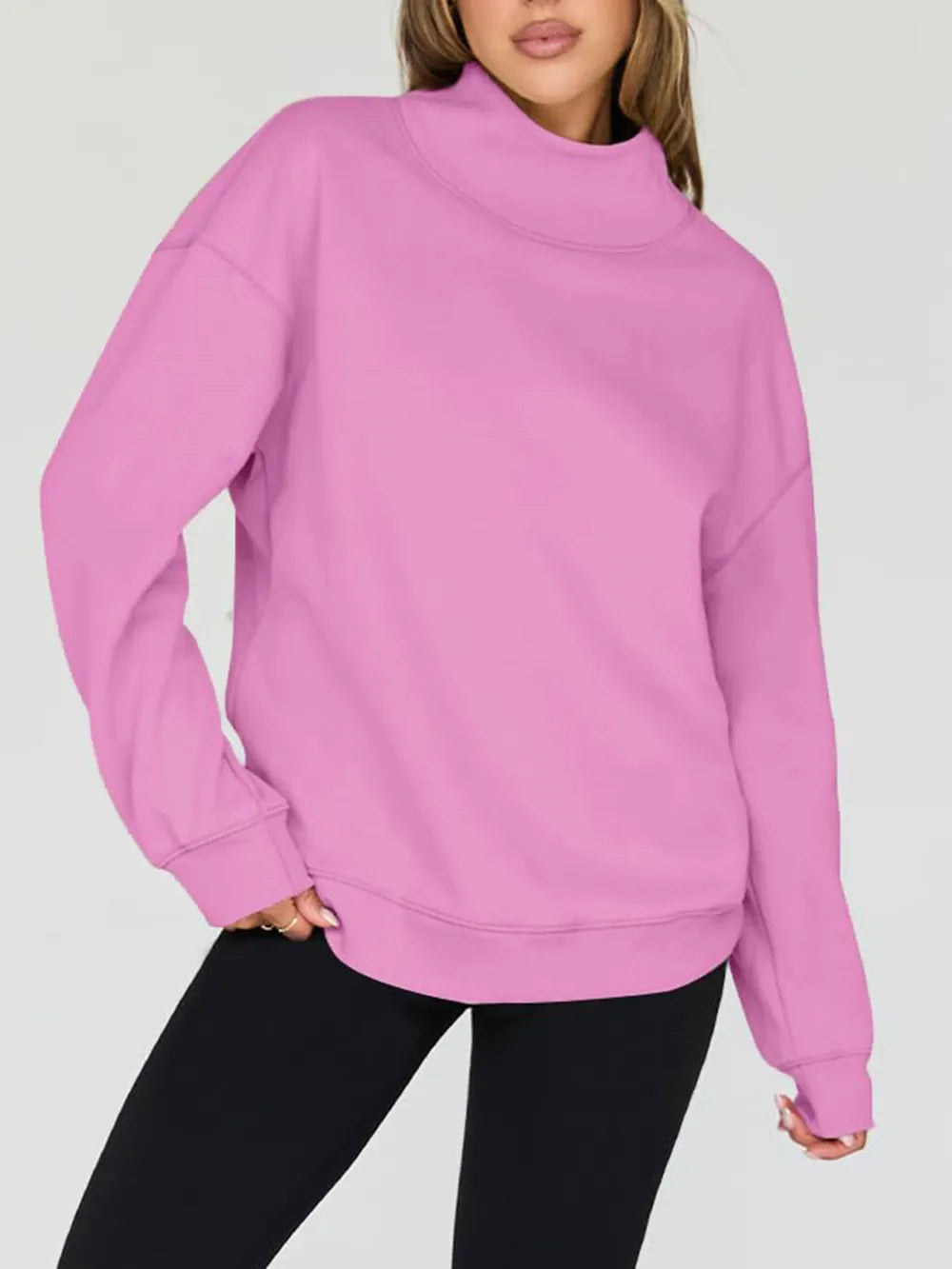 Person wearing a pink sweatshirt on a plain background