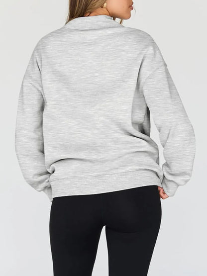 Person wearing a gray sweatshirt against a plain background