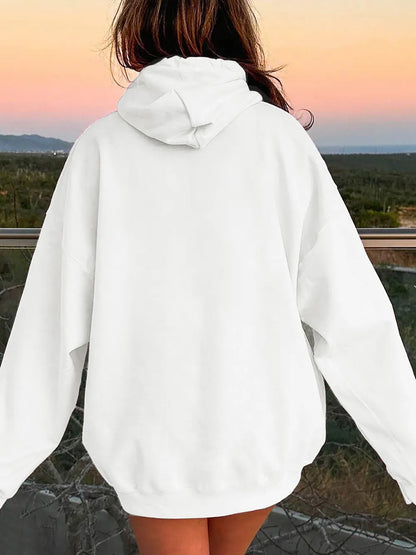 Person wearing a white hoodie with a scenic background