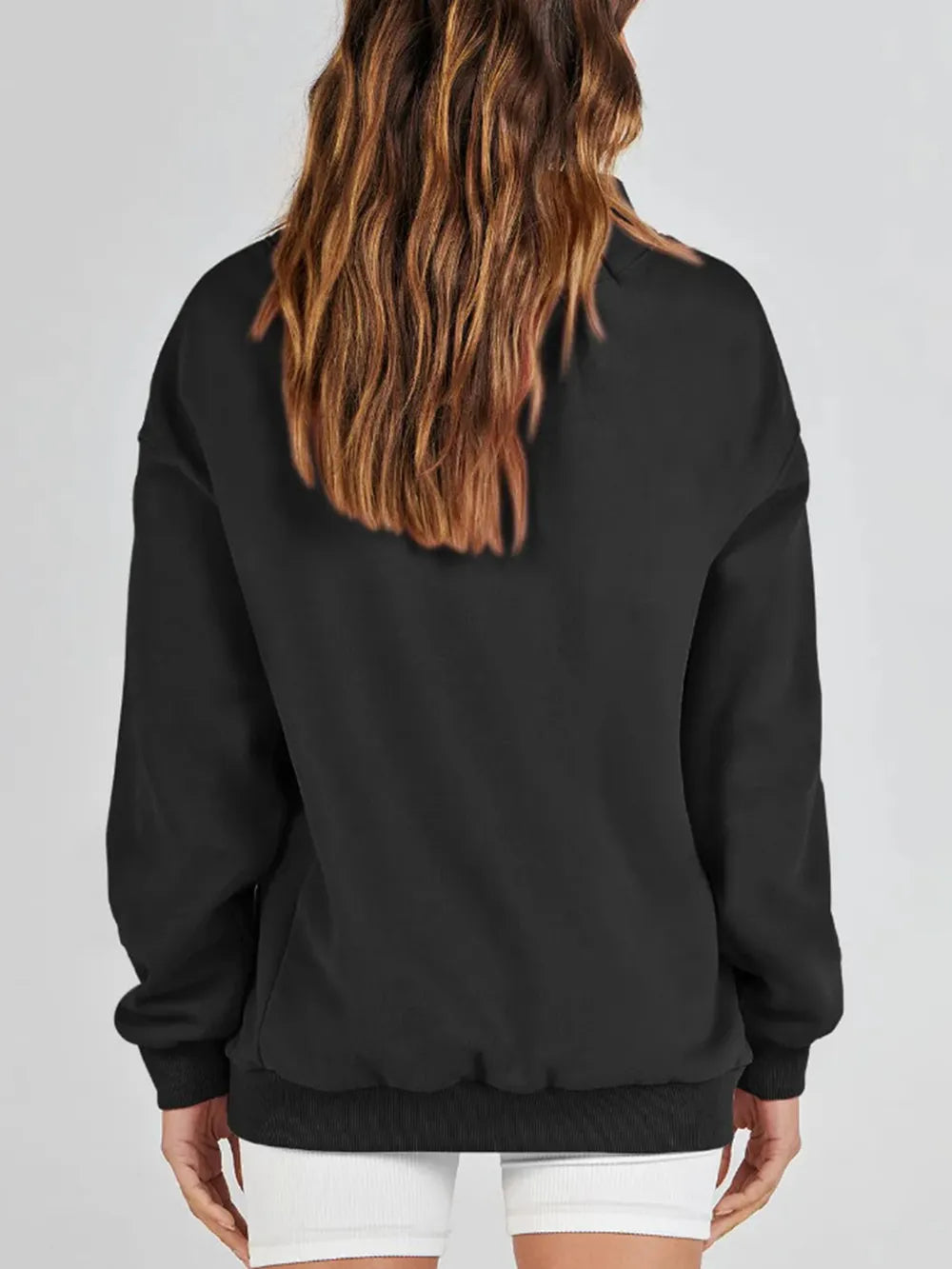 Person wearing a gray sweatshirt against a plain background