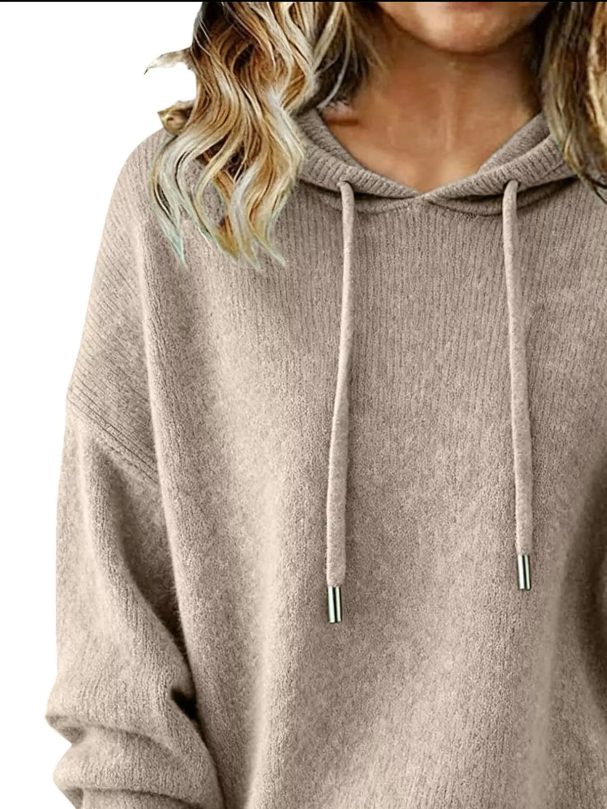 Beige hoodie worn by a person with blonde hair on a white background