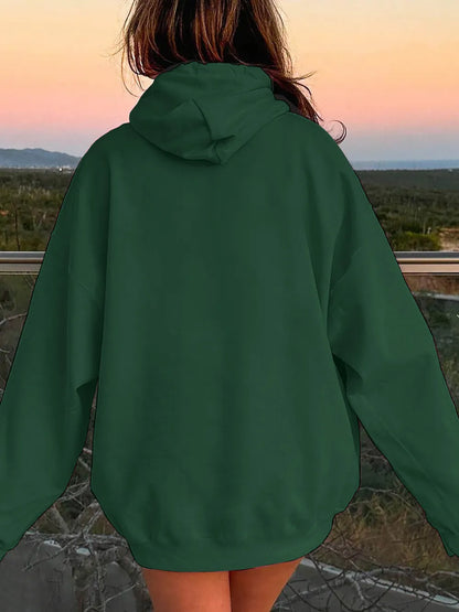 Person wearing a green hoodie with a scenic background