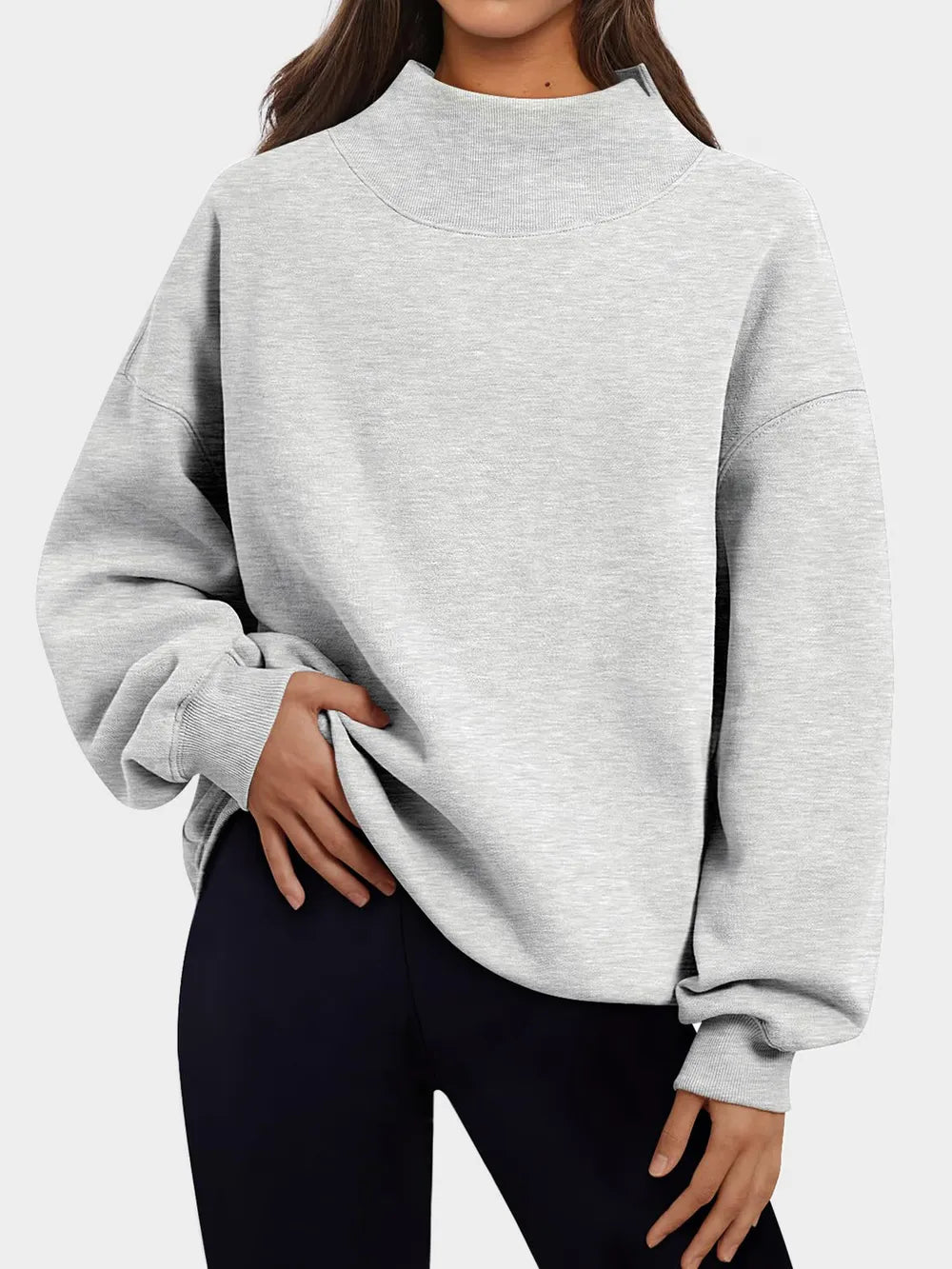 Person wearing a gray sweatshirt against a plain background