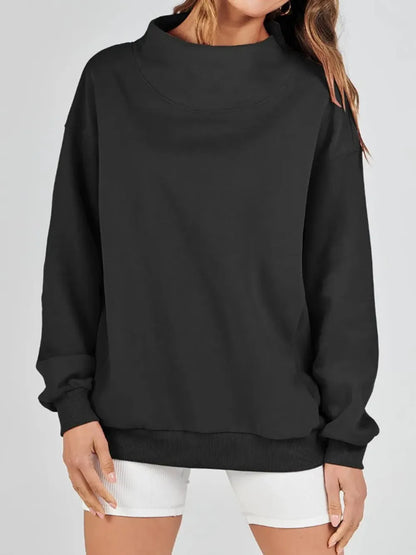 Person wearing a gray sweatshirt against a plain background