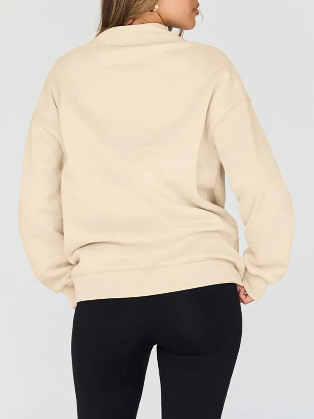 Beige sweatshirt worn by a person on a plain background