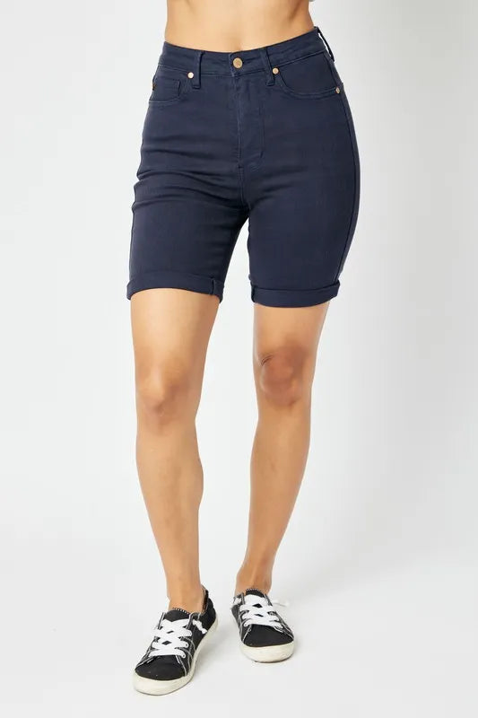 Person wearing navy blue shorts on a white background
