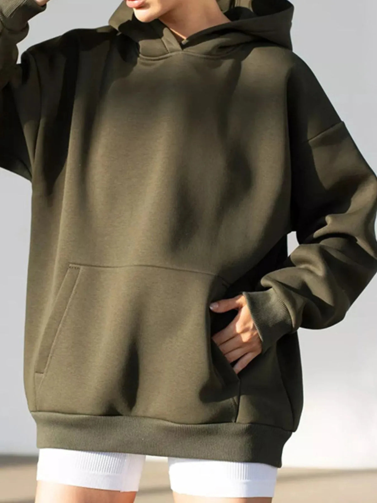 Person wearing a green hoodie on a plain background