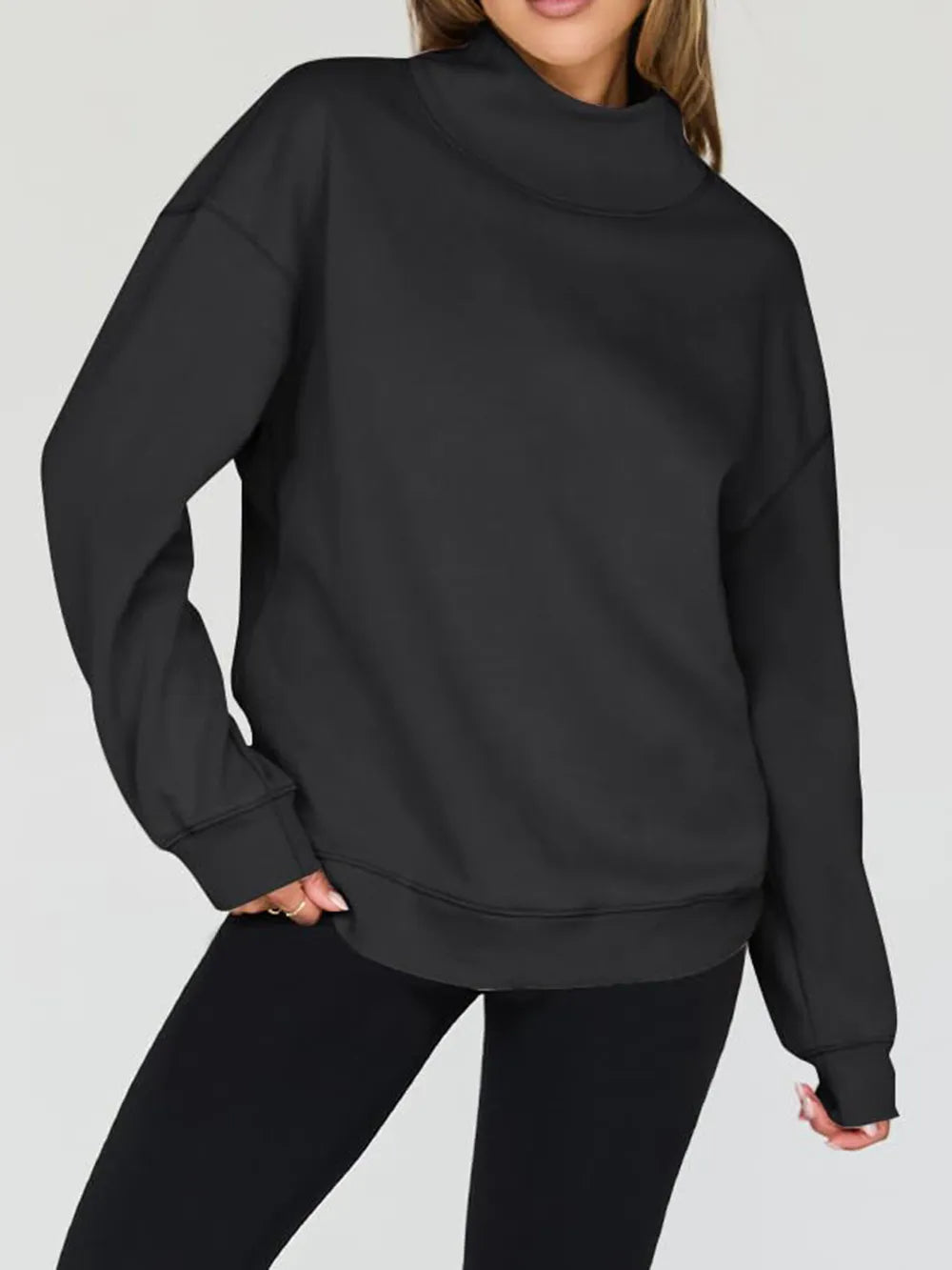 Person wearing a black sweatshirt and pants on a light gray background