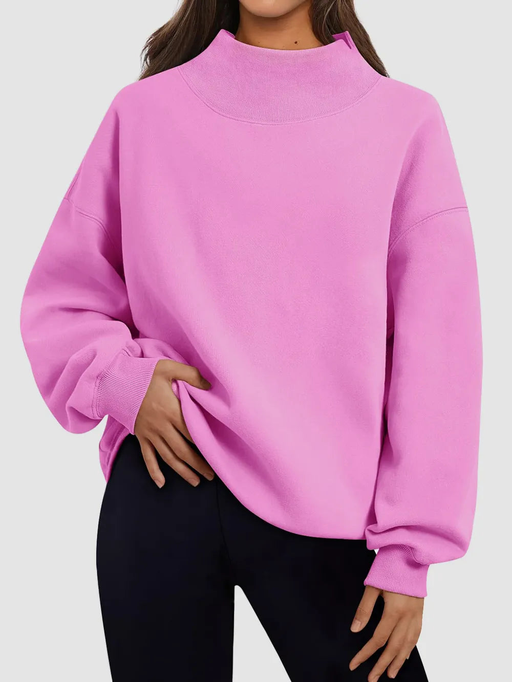 Person wearing a pink sweatshirt on a plain background