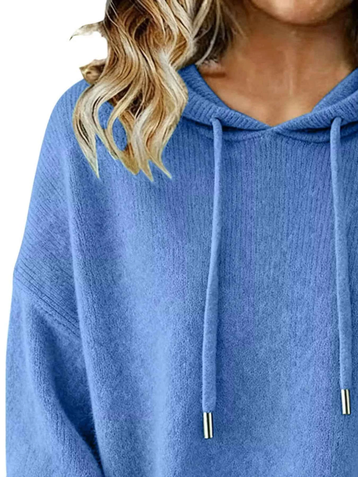 Blue hoodie worn by a person with blonde hair, close-up view.