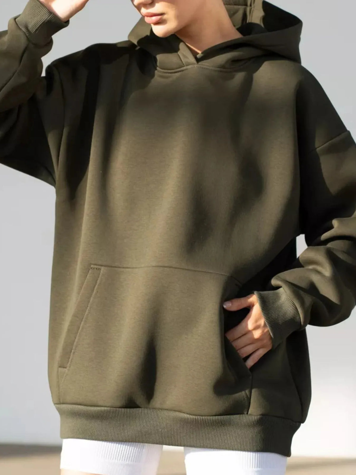 Person wearing a green hoodie on a plain background