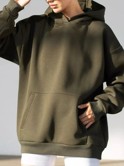 Person wearing a green hoodie on a plain background