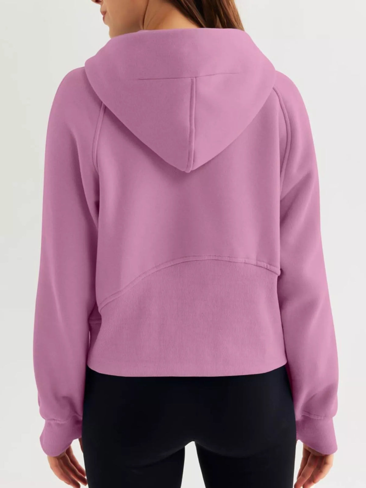 Pink hoodie worn by a person on a white background