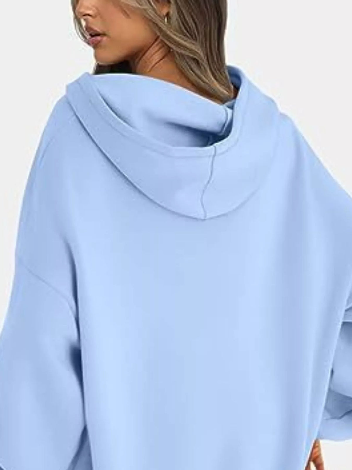 Light blue oversized hoodie worn by a person on a white background