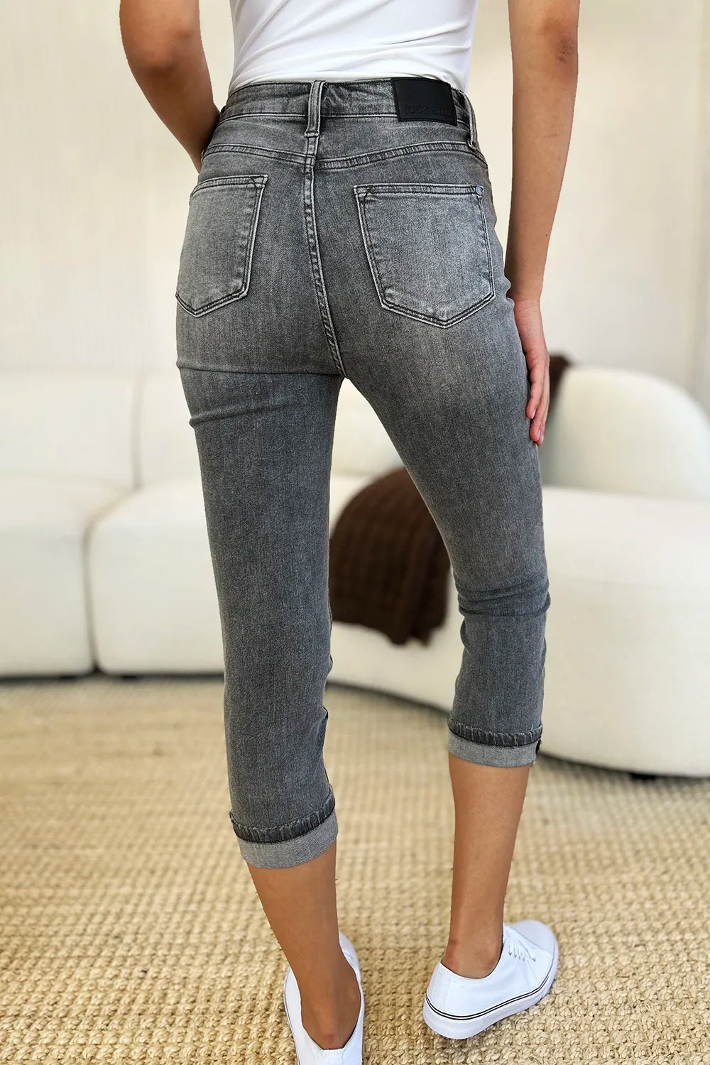 Person wearing gray jeans with a blurred background