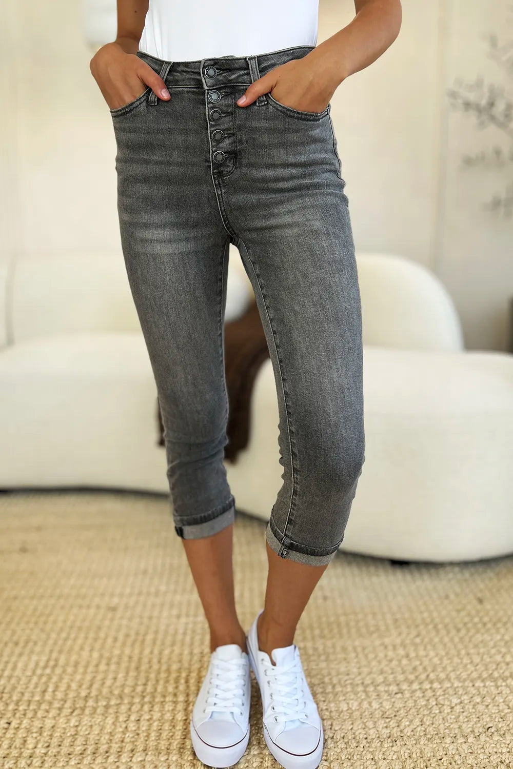Person wearing gray jeans and white sneakers in a casual setting