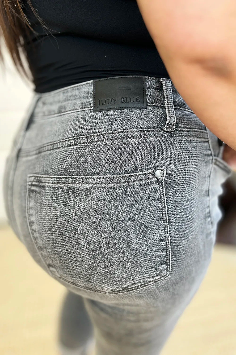 Gray jeans with a brand label on a neutral background