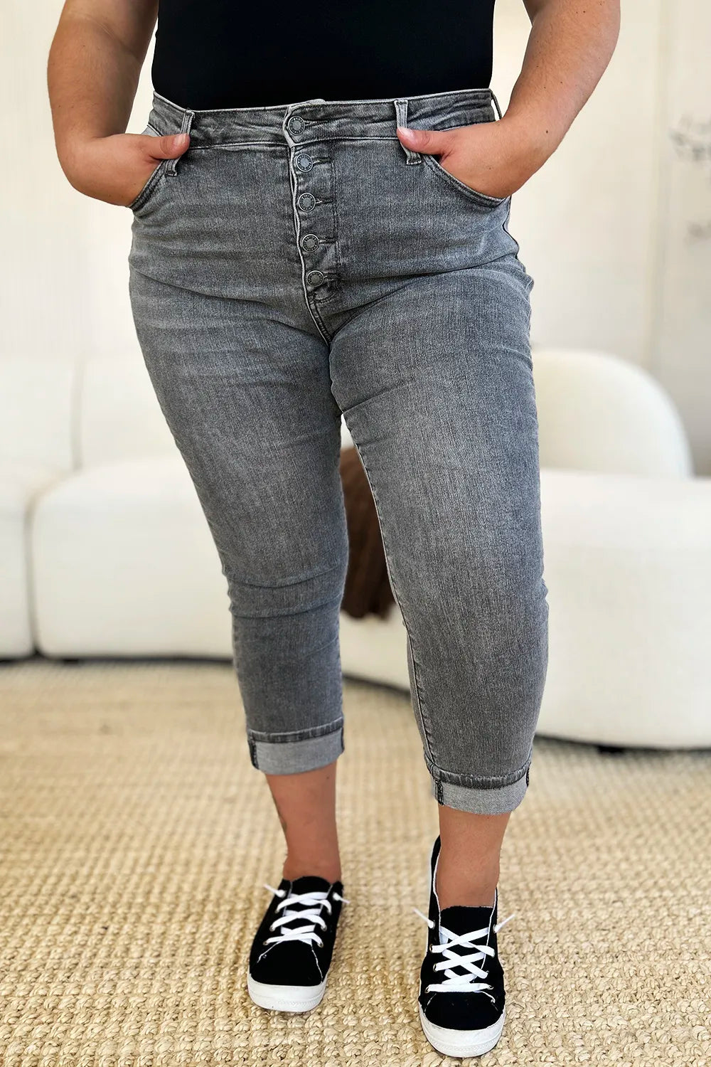 Person wearing gray jeans and black sneakers in a casual setting