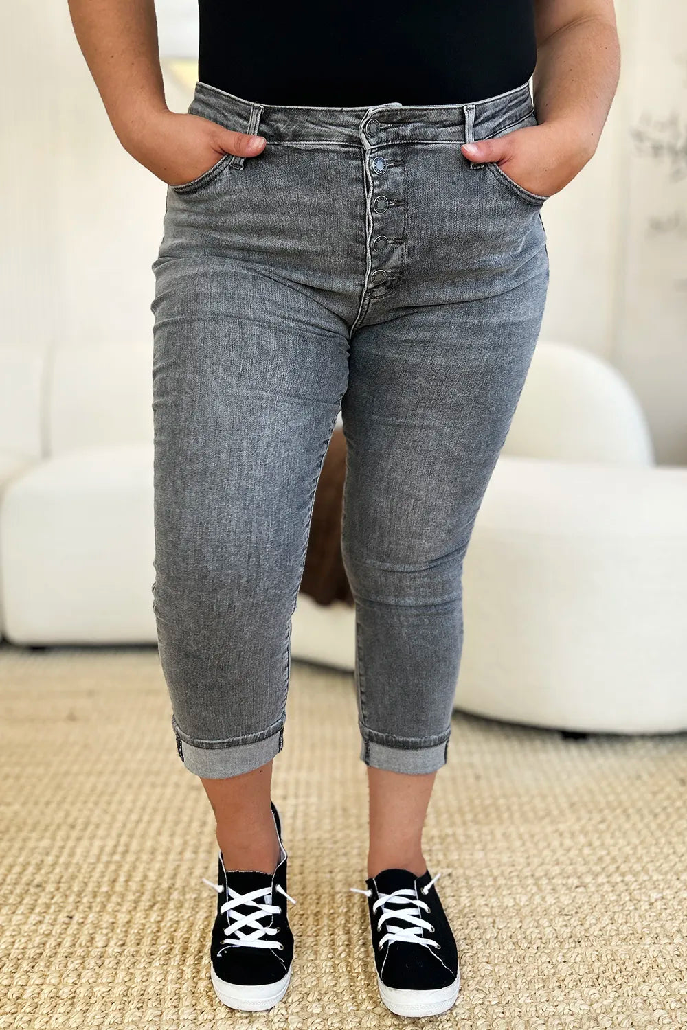 Person wearing gray jeans and black sneakers in a casual setting