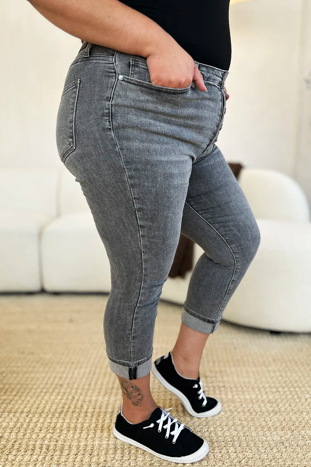 Person wearing gray jeans and black sneakers in a casual setting