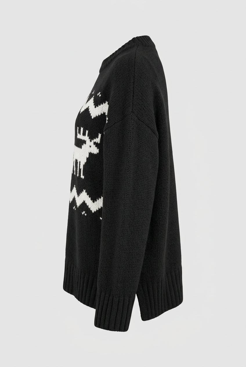 Left side view of a premium black wool-blend pullover sweater highlighting the relaxed luxury silhouette, thick ribbed wrist cuffs, and side profile of the reindeer motif.