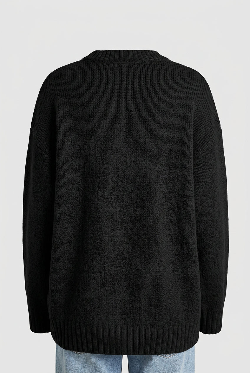 Back view of a high-end loose-fit black alpaca-wool blend knit sweater showing the dense fabric texture, ribbed crewneck collar, and straight casual hemline.