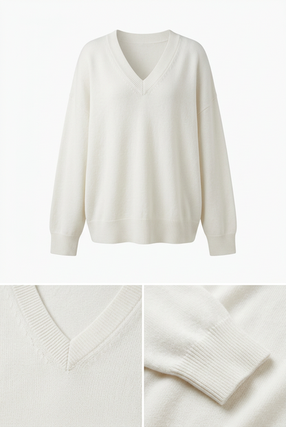 Woman wearing a white oversized ribbed knit V-neck sweater featuring long sleeves, side-slit hem, relaxed fit silhouette, and soft textured fabric for cozy everyday.