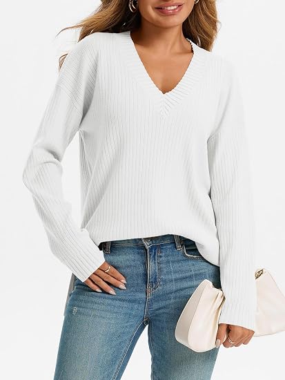 Woman wearing a white oversized ribbed knit V-neck sweater featuring long sleeves, side-slit hem, relaxed fit silhouette, and soft textured fabric for cozy everyday styling.