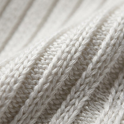 Woman wearing a white oversized ribbed knit V-neck sweater featuring long sleeves, side-slit hem, relaxed fit silhouette, and soft textured fabric for cozy everyday styling. Color & Features and Specs