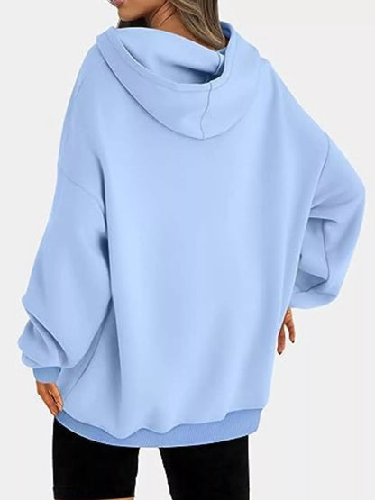 Light blue oversized hoodie worn by a person on a white background