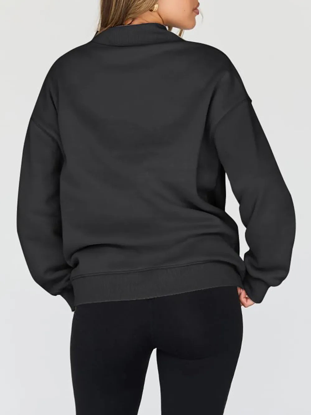 Person wearing a gray sweatshirt against a plain background