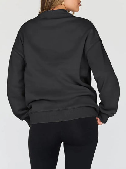 Person wearing a gray sweatshirt against a plain background
