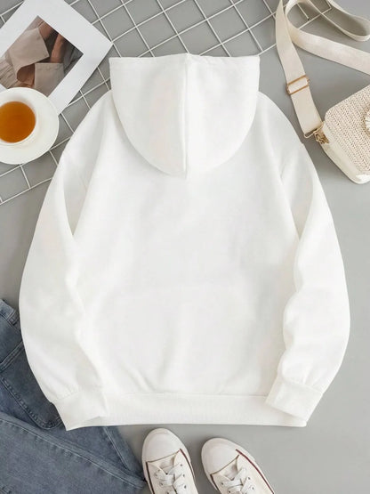 White sweatshirt on a gray surface with jeans and sneakers