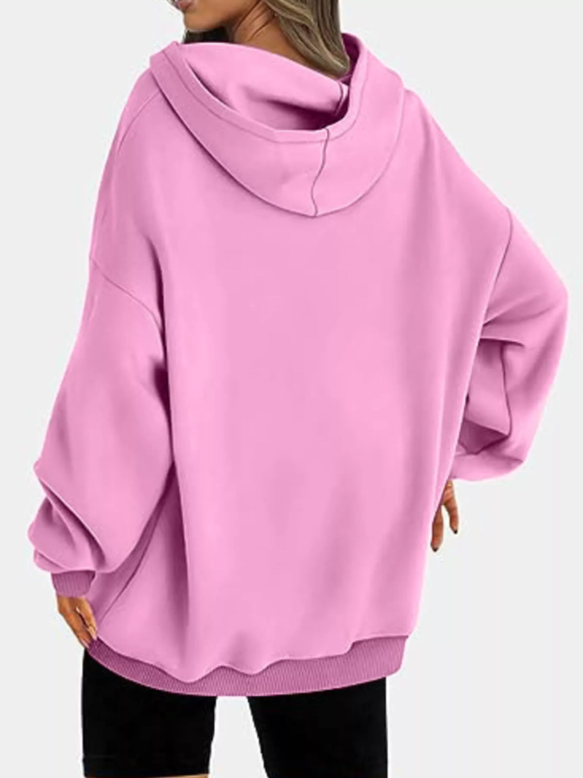 Pink hoodie worn by a person on a white background