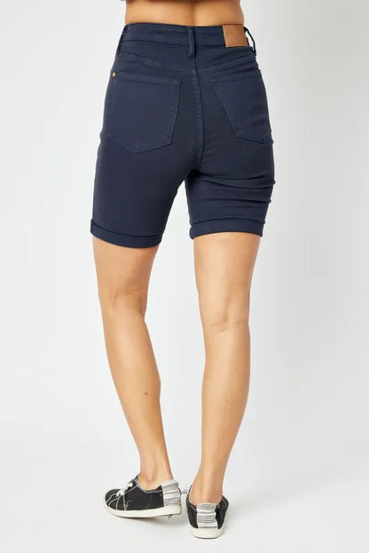 Navy blue shorts worn by a person on a white background
