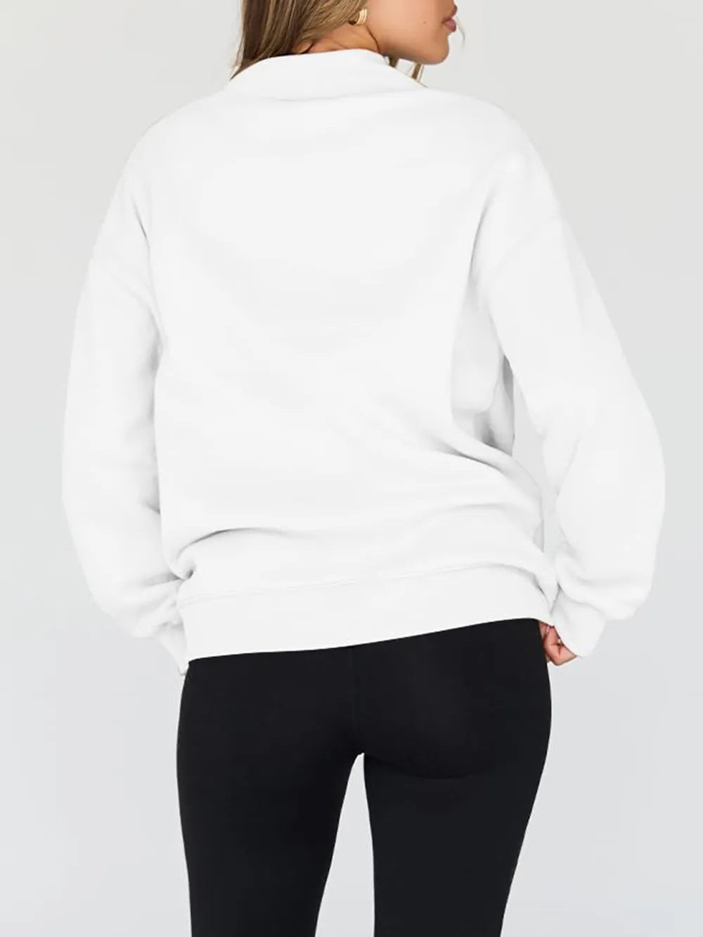 Person wearing a white sweatshirt and shorts on a plain background