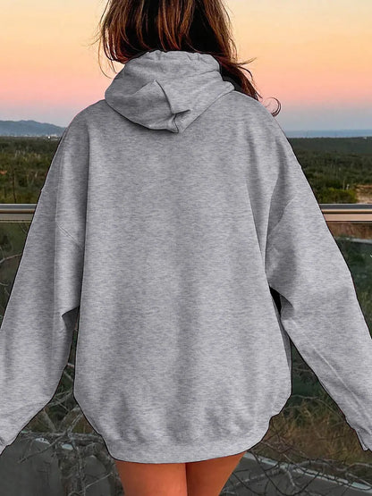 Person wearing a gray hoodie with a scenic background