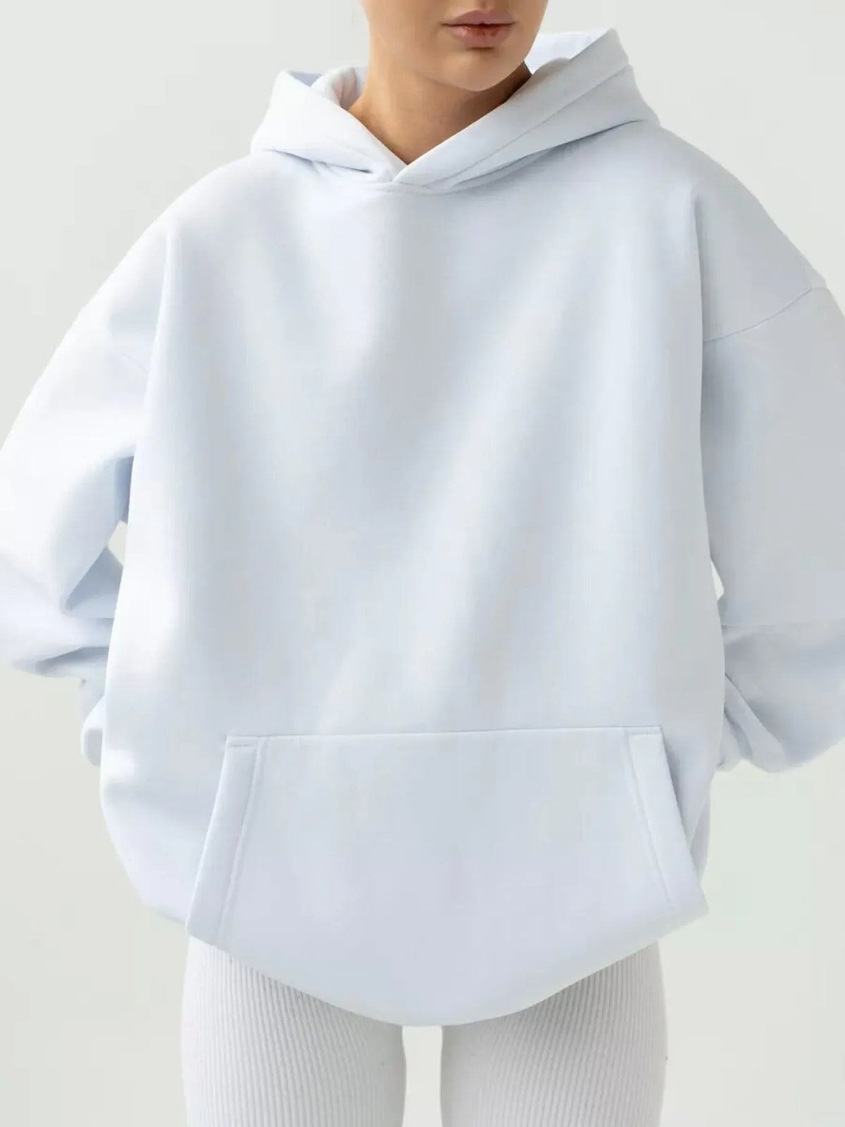 White hoodie worn by a person on a light gray background